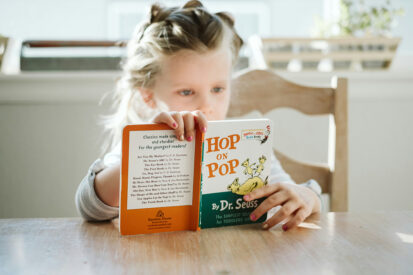 girl sitting while reading book